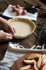 Donna irriconoscibile che fa una torta di mele su un tavolo di legno — Foto stock