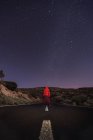 Viaggiatore in piedi su strada vuota di notte — Foto stock