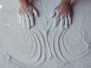 Mains d'un artiste masculin anonyme étalant du plâtre blanc rugueux sur une surface plane en atelier — Photo de stock
