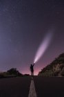 Viajante de pé com tocha na noite estrelada — Fotografia de Stock
