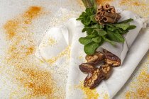 Dried dates, figs, fresh mint and cinnamon for halal snack on white cloth with spices — Stock Photo
