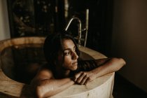 Vue latérale d'une jolie femme prenant son bain dans une maison rustique — Photo de stock