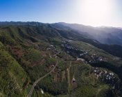 Vue aérienne de la route sinueuse à travers le paysage de montagne en plein soleil — Photo de stock