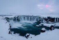 Vista da poderosa cachoeira Godafoss e falésias cobertas de neve na Islândia — Fotografia de Stock