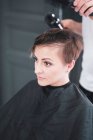 Friseur trocknet Frau die Haare — Stockfoto