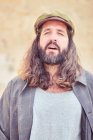 Stylish bearded man with long hair looking at camera — Stock Photo