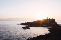 À beira-mar rochoso remoto ao pôr do sol brilhante — Fotografia de Stock