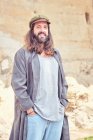 Stylish bearded man with long hair on street posing and looking at camera — Stock Photo