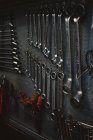 Conjunto de ferramentas de reparo sortidas anexado à parede de metal grungy na oficina profissional — Fotografia de Stock