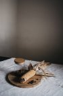 Milho seco em espiga colocada em tábua de madeira perto de jarro com especiarias marrons na mesa da cozinha — Fotografia de Stock