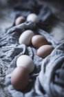 Курячі яйця на скатертині на сільському дерев'яному столі — стокове фото