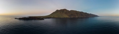 Панорамний вид на берегову лінію з величними скелями і темними хвилями на заході сонця — стокове фото