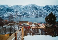 Pequena cidade perto do mar e montanhas nevadas — Fotografia de Stock