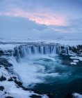 Blick auf mächtige godafoss Wasserfall und Klippen mit Schnee in Island bedeckt — Stockfoto