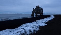 Vista pitoresca da praia de seixos e formação de rochas sob o céu sombrio em Hvtserkur Islândia — Fotografia de Stock