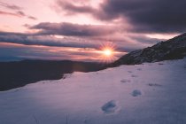Sole che tramonta sulle montagne innevate — Foto stock
