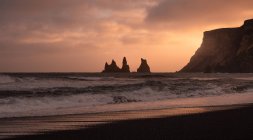 Пляж і рок утворень на заході сонця в Ісландії вік піщаний пляж — стокове фото