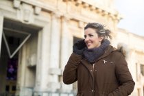 Young woman in winter clothes talking on the phone outdoors in Milan Italy — Stock Photo
