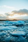 Тріснутий льодовиковий шар на воді з горами — стокове фото