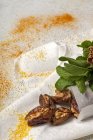 Snack halal para Ramadán con dátiles secos, higos, menta fresca y canela sobre tela blanca - foto de stock