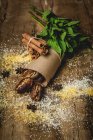 Getrocknete Datteln, Feigen, frische Minze und Zimt als Halal-Snack für Ramadan, eingewickelt in Pergament auf Holztisch — Stockfoto