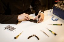 Молодий чоловік ремонтує сучасний пристрій — стокове фото