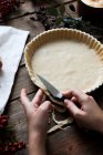 Mulher irreconhecível fazendo uma torta de maçã em uma mesa de madeira — Fotografia de Stock