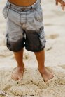 Funny African American boy with playing on sandy shore near sea — Stock Photo