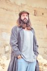 Stylish bearded man with long hair on street posing and looking at camera — Stock Photo