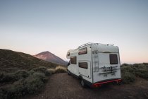 Wohnwagen am Straßenrand in Wüstenlandschaft vor dem Hintergrund des Berges im Morgenlicht — Stockfoto