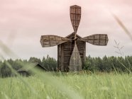 Involucrando viejo molino de viento de madera en la frontera del campo y el bosque en Finlandia - foto de stock