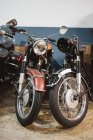 Shabby moto d'epoca con fari rotti parcheggiate all'interno officina di riparazione — Foto stock