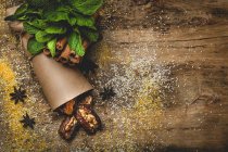 Сушеные финики, инжир, свежая мята и корица для халяльной закуски для Рамадана, завернутые в пергамент на деревянном столе — стоковое фото