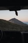 Вид на гору через окно автомобиля на закате — стоковое фото