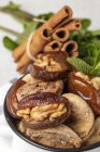 Крупный план сушеных фиников, инжира, свежей мяты и корицы для халяльной закуски для Рамадана в банке — стоковое фото