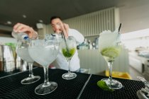 Barman prepara bebidas alcoólicas em bar — Fotografia de Stock