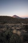 Гірський пік у пустельній долині на заході сонця — стокове фото