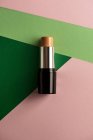 Concealer stick on modern background with geometric shapes. Product and makeup concept from above. — Stock Photo