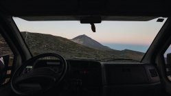 Vue de la montagne à travers la fenêtre de la voiture au coucher du soleil — Photo de stock