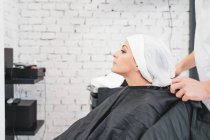 Стилист стирает волосы юной леди — стоковое фото