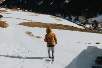 Mann läuft auf Fußweg in verschneiter Landschaft — Stockfoto
