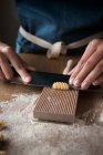 Анонімні жінки готують тісто для домашньої пасти на дерев'яному інструменті в столі на кухні — стокове фото