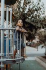 Afrikanischer amerikanischer Junge schaut weg, während er hinter Gittern auf Spielplatz im Park steht — Stockfoto
