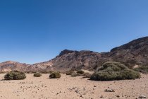 Cima di montagna in un'area desertica selvaggia sotto il cielo blu — Foto stock