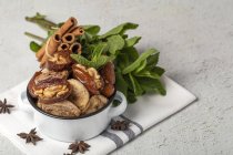 Dried dates, figs, fresh mint and cinnamon for halal snack for Ramadan in pot on kitchen towel — Stock Photo