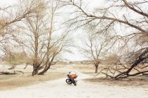 Motocicleta situada en la estrecha carretera de campo en el campo seco durante el viaje en la naturaleza - foto de stock