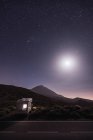 Путешествующий караван в пустыне с яркой луной и звездным небом — стоковое фото