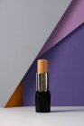 Concealer stick on modern background with geometric shapes. — Stock Photo