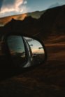 Reflection on asphalt countryside road and majestic sundown sky in wing mirror of sky during travel in nature — Stock Photo