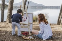 Mutter und Junge malen am See — Stockfoto